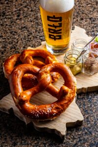 brlo beer with pretzels on germany shaped cutting board